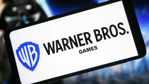 Getty Images Warner Bros Games logo displayed on a white phone screen in front of a Star Wars themed background. 