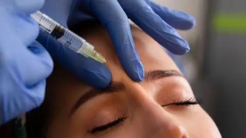 A woman has a substance injected between her eyebrows