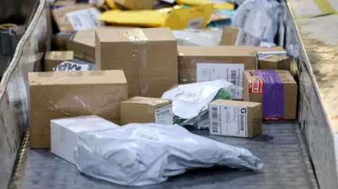 Packages roll along a conveyor belt as the US Postal Service prepares them for delivery.