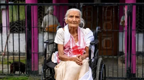 A 97-year-old Lokada Duarah was carried onto a banana tree trunk and taken to safety after floodwaters rose around her home