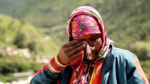 Indian woman wipes tears with headscarf