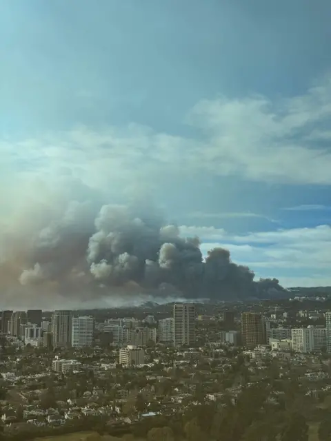 Getty Images Thick smoke from the Palisades Fire rises over a wide view of Los Angeles on Wednesday.