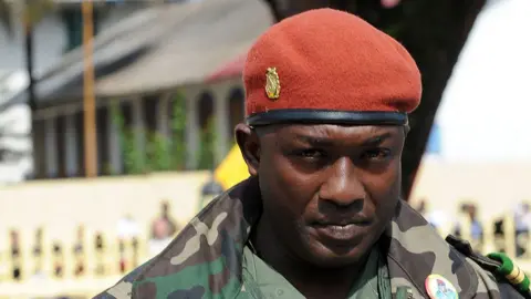 AFP via Getty Images A close up of Aboubacar Sidiki Diakité. He is wearing military clothing - a red beret with a gold pin on the side and green fatigues. he is outdoors.