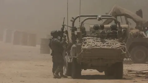 Reuters Israeli soldiers stand next to a military vehicle, near the Israel-Gaza border (2 July 2024)