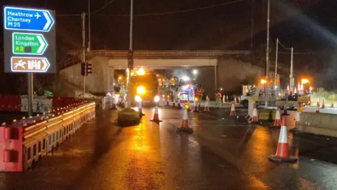 Workers at the M25 Junction 10, with cones and National Highways lorries in the road