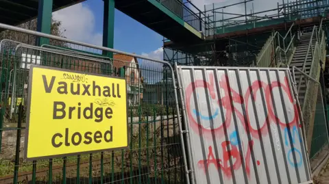 Local Democracy Reporting Service A "Vauxhall Bridge closed" sign next to fences and steps.