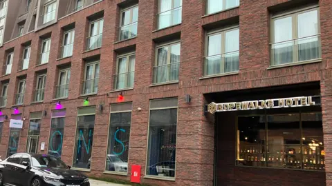 An exterior view of the Seel Street Hotel. It is a red-brick building in the centre of Liverpool, with glass panelled windows. 