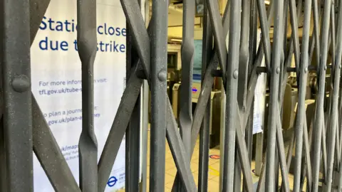 BBC/Harry Low Metal shutters drawn across 'station closed due to strike' sign