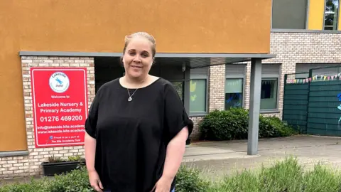 Sara Thornton / BBC A woman wearing a black top stood in front of a building.