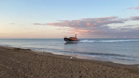 Skegness RNLI's Shannon class all-weather lifeboat - the Joel and April Grunnill - is pictured coming ashore at Skegness beach on an early summer's evening. 
