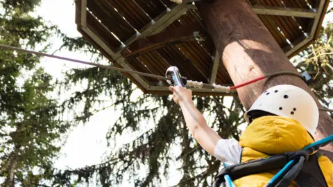 Getty Images Child attaching themselves to a zip wire