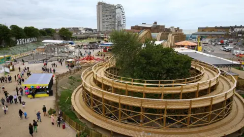 PA Media Bends on a large wooden rollercoaster track, seen from above. Other parts of a theme park can be seen in the background.