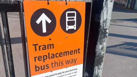 An orange sign for a tram replacement bus