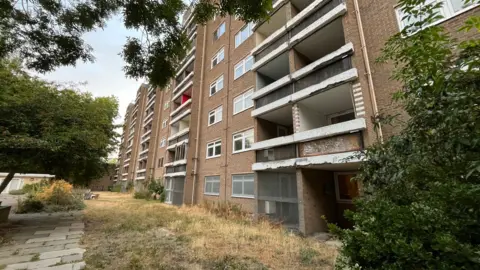 General view of a block of council flats, a brick building which is seven storeys high.