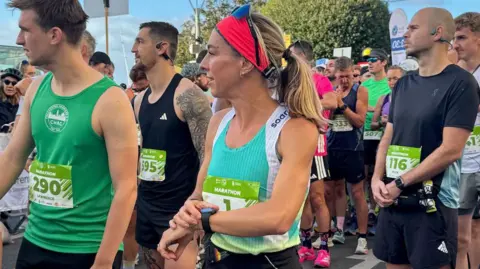 Alice Braham Sekelompok orang mengenakan oto lari dan menunggu maraton dimulai.