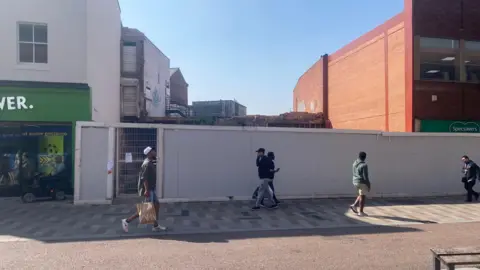 A streetview of an empty gap between two buildings