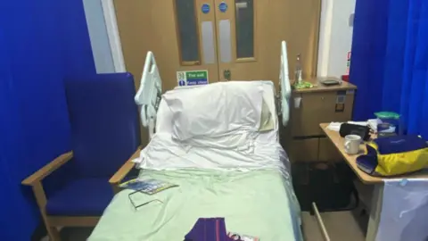 BBC Hospital bed in front of emergency fire doors