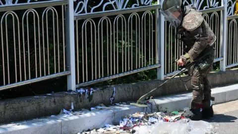 Yonhap A South Korean worker  successful  protective instrumentality  scans rubbish dumped by a North Korean balloon.