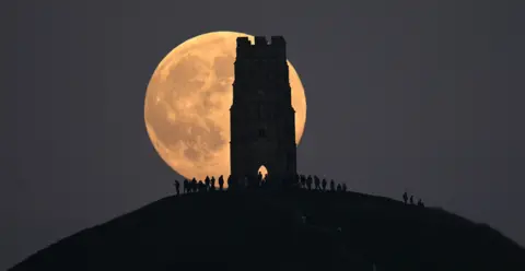 Jeff Overs A huge supermoon can be seen behind Glastonbury Tor, a Grade I listed building in Somerset.