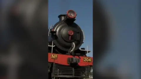 Face-on view of a black steam locomotive.