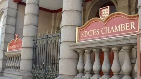 The States Chamber building with a black spiked door fence and States of Chamber written in gold