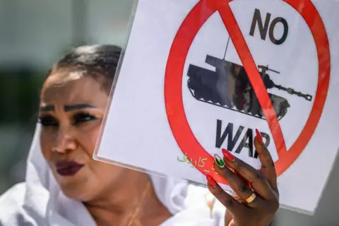 AFP A woman at a protest in Geneva, Switzerland, against the Sudanese war.