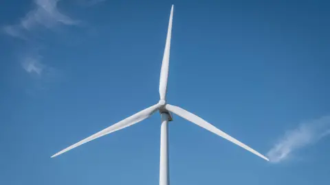 White, three-blade turbine against a blue sky