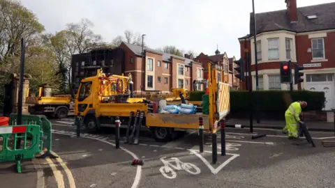 LDRS Yellow council lorry and a workman at a junction in Heaton, Newcastle, as the bollards for the low traffic neighbourhood scheme were removed in April