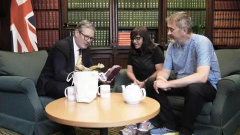 PA Media Figen Murray, mother of Manchester Arena bombing victim Martyn Hett, and her husband Stuart speaking to Labour Party leader Sir Keir Starmer (left) about Martyn's Law in the Houses of Parliament in London, after her 200-mile walk to London from the spot where her son was killed in Manchester. 