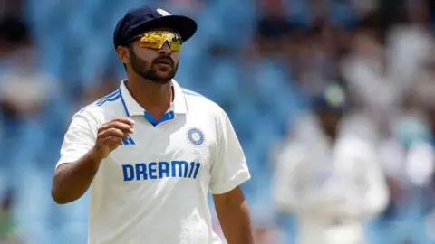 A close up of Shardul Thakur in his sunglasses in the field for India 