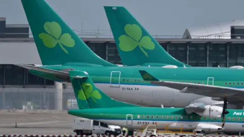 PA A number of Aer Lingus planes parked on an airport runway