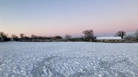 A field covered in snow at sunrise