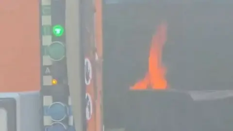 A flame from inside the bin lorry as it catches fire.
