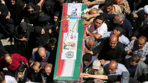 Mourners attend a funeral for those killed in Israeli strikes on Iran