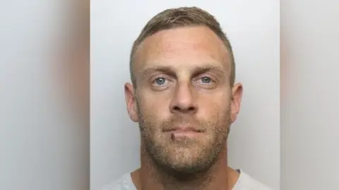 South Yorkshire Police A mugshot of Chadwick who has blue eyes and blond hair. He has a five o'clock shadow and appears to have a cut on his lower lip.