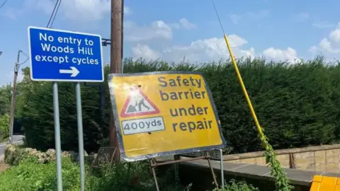 BBC A roadworks sign saying "Safety barrier under repair in 400 yds"