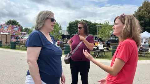 Soucek (right) discusses the economy with Conway (left) and other female voters.