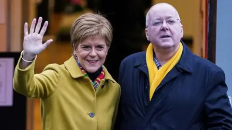 Getty Images First Minister of Scotland and leader of the SNP Nicola Sturgeon votes with her husband Peter Murrell at Broomhouse Community Hall in Ballieston on December 2019
