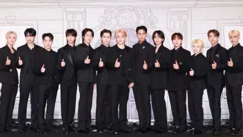 Getty Images Members of the K-pop band Seventeen stand in a line