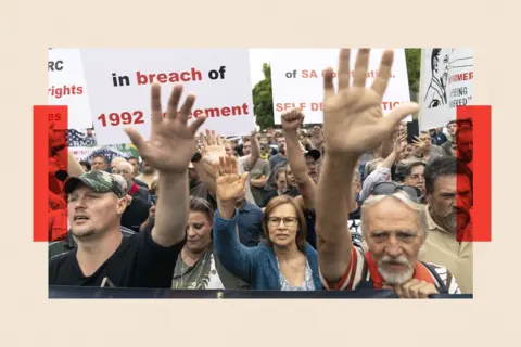 EPA-EFE/REX/Shutterstock Afrikaaner farmers in South Africa rally with their hands in the air