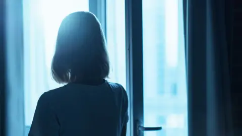 Woman silhouette in front of the window