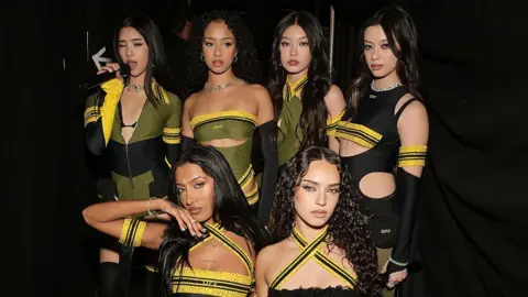 Getty Images Six-member girl group Katseye in black, yellow and green outfits at the Grammy Awards.