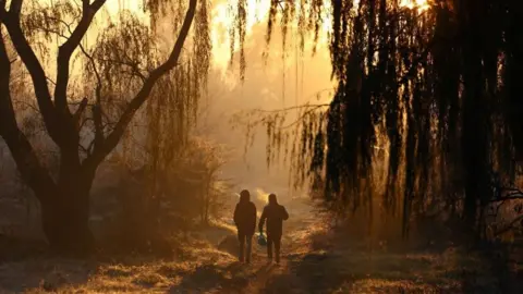 Siphiwe Sibeko/Reuters Two men take a walk on a winter in the south of Johannesburg, South Africa on 12 June.