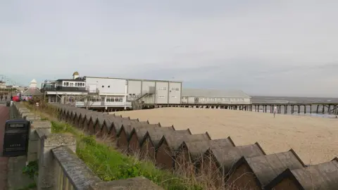Martin Giles/BBC A wide shot of the side of Claremont Pier taken from the promenade. The pier buildings are on the left, with the empty pier structure on the right. The end of the pier is not in the picture. 