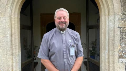 Reverend Steve Wilkinson in front of church