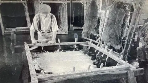 Alan Hooper A man working on a sheepskin tannery machine
