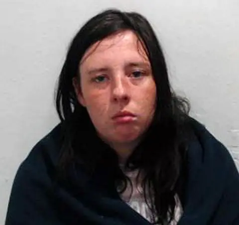 Police Scotland A dark haired woman in a dark top staring at the camera