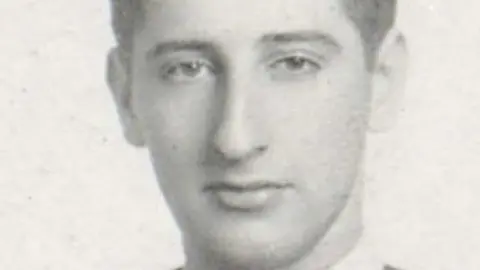 Bryan Urbick A black and white photo of a young man with dark hair.