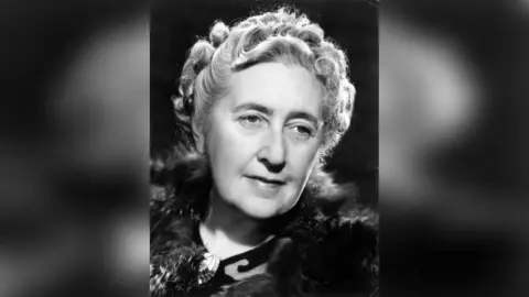 A black-and-white image of Agatha Christie. She is wearing a fur coat and has curled hair. 