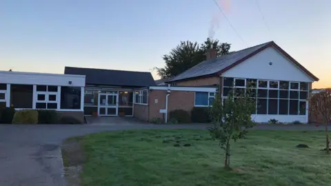 A school building, pictured at sunset.